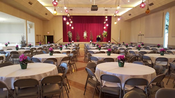 Napredak hall set up with round tables and floral centerpieces for the event