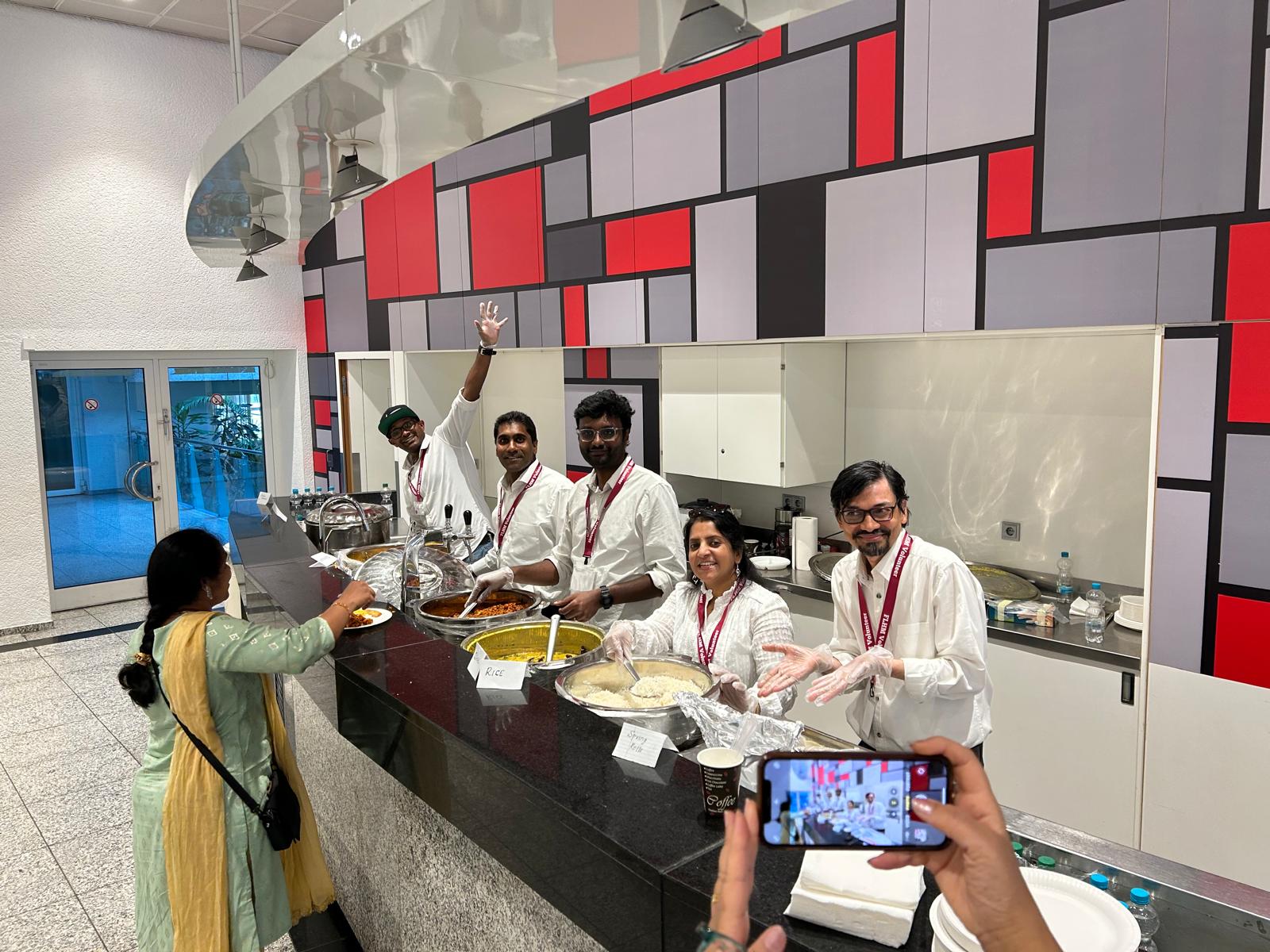 Volunteers serving Indian food at the HMEurope Frankfurt event buffet