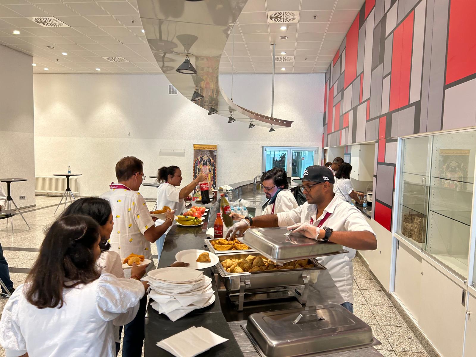 Buffet line with samosas and refreshments served by volunteers at the HMEurope Frankfurt event